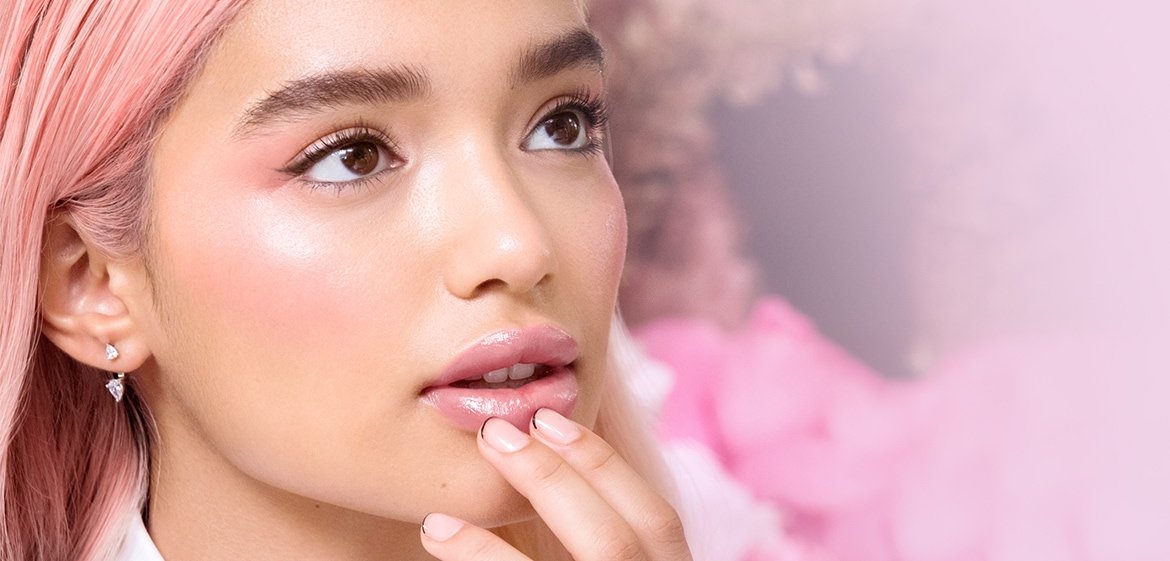 Eine junge Frau mit pinken Haaren und passendem Make-up